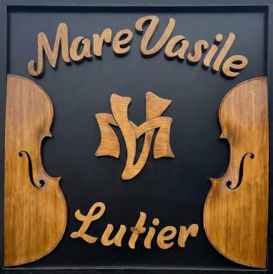 Das geschnitzte Emblem der Werkstatt Mare Vasile — zwei Geigenhälften und das MV-Monogramm